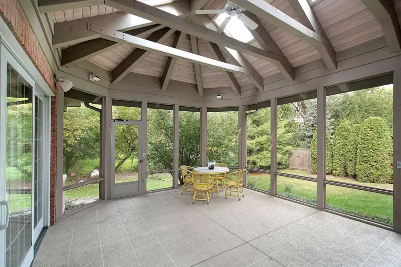 A screened patio room with a vaulted wood ceiling